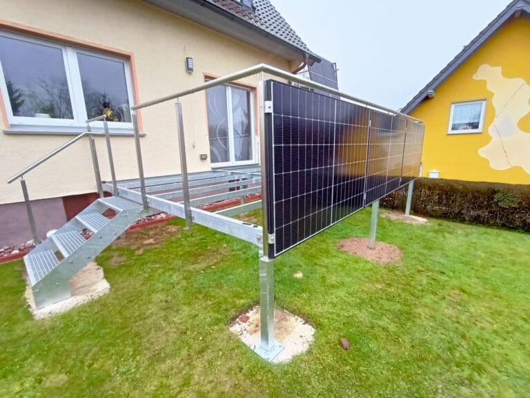 Kompakter Stahlbalkon mit Außentreppe und montierten Solarmodulen