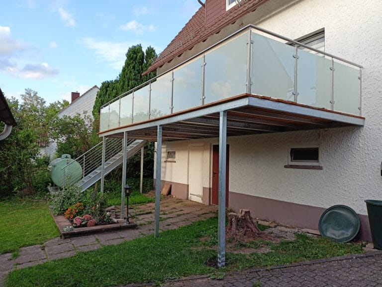 Stahlbalkon mit Glasgeländer und Außentreppe an einem bestehenden Wohnhaus