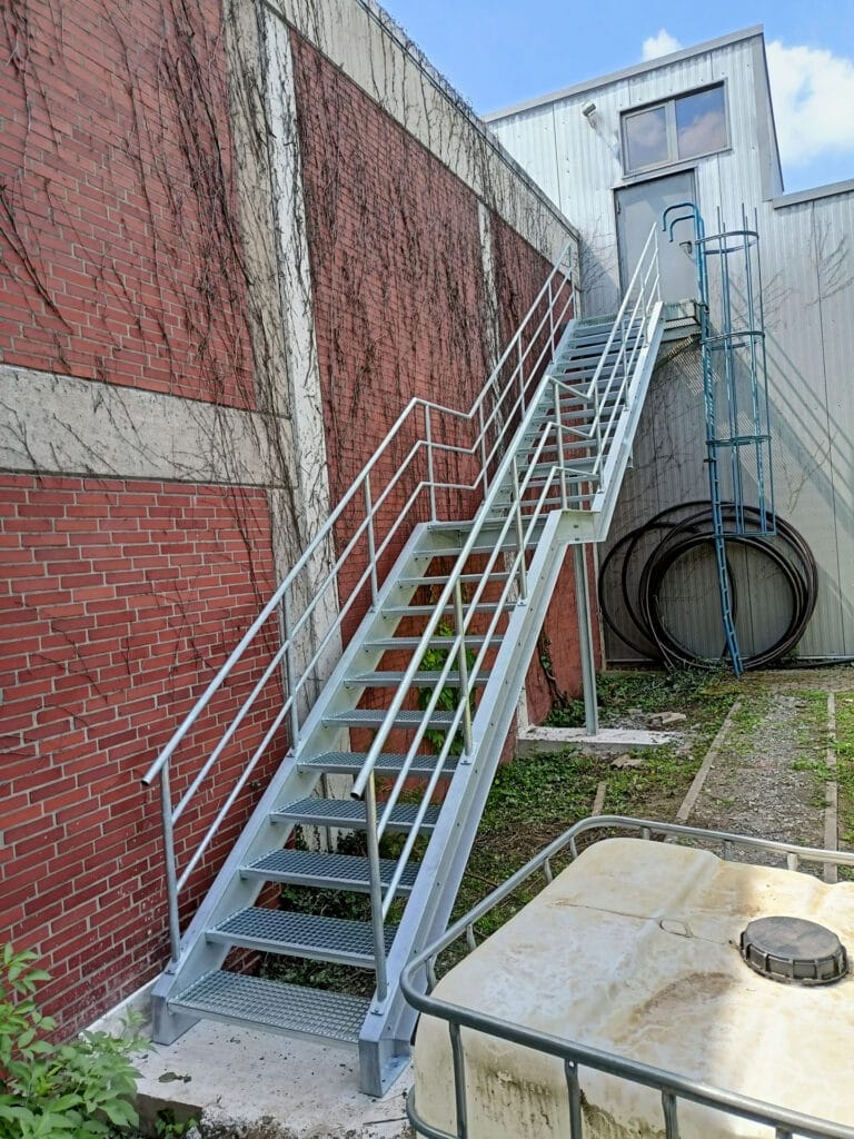 Verzinkte Industrietreppe mit Sicherheitsgeländer an einem Betriebsgebäude