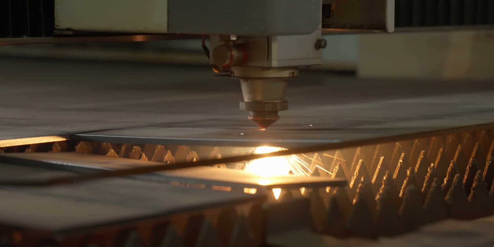Laserteile richtig anfragen Laserschneidkopf beim präzisen Zuschnitt eines Metallbauteils